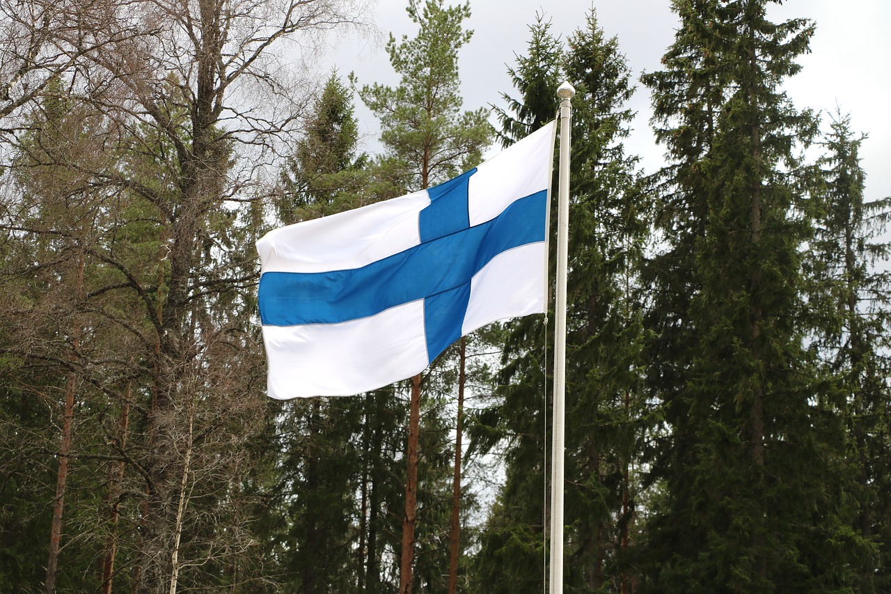 the Finnish flag flying with trees in the background
